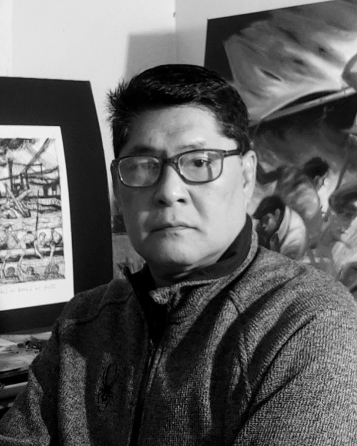 Portrait of Filipino painter Jeho Bitancor seated before two artworks
